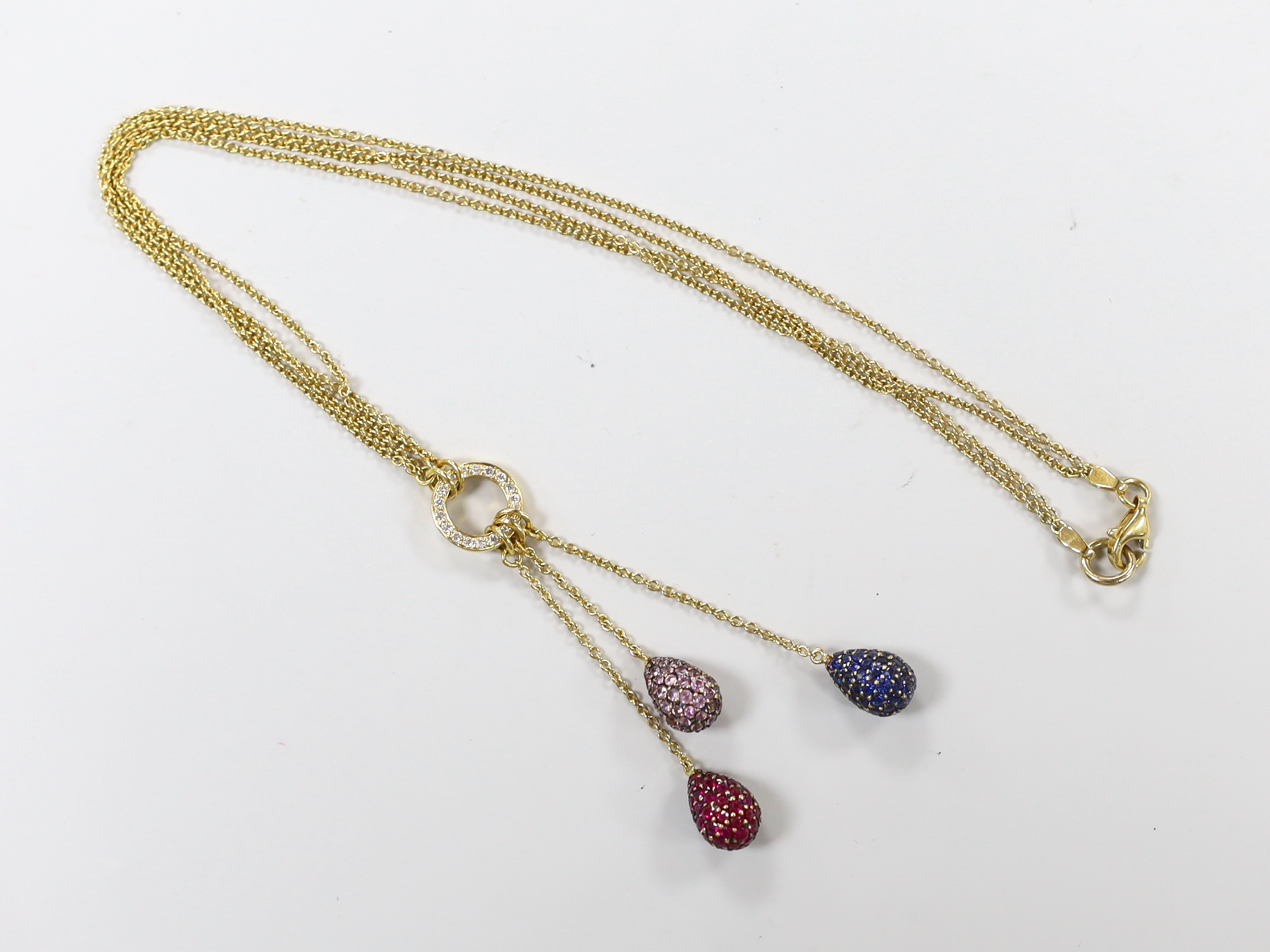 A modern 750 yellow metal, diamond chip and three colour gem pave set triple pear shaped drop pendant necklace, 51cm, gross weight 10.9 grams.